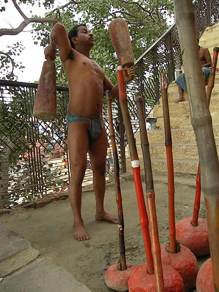 पारंपरिक भारतीय आखाड्याच्या मातीवर सराव करणारा एक मल्ल